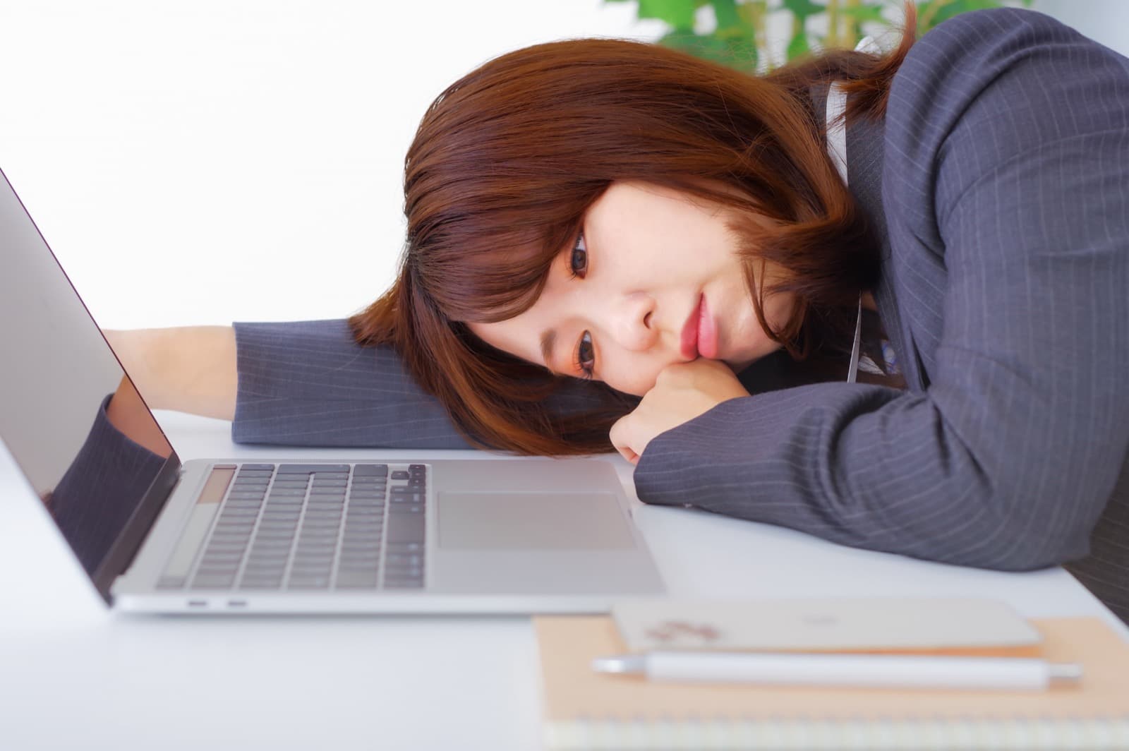 ノートパソコンの前で仕事を辞めたい気持ちについて考え込む女性